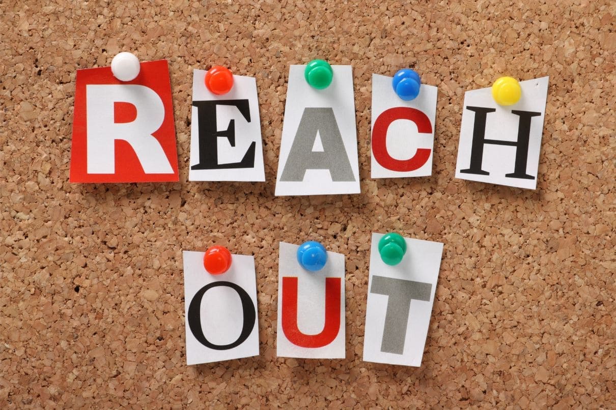 Cork board with reach out cutouts, representing connection and communication.